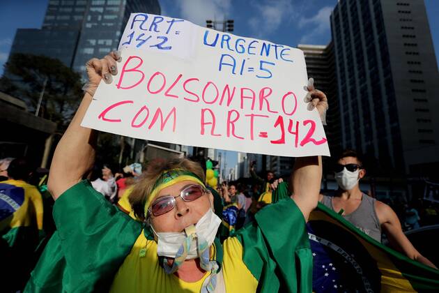 A woman with a facial mask waves a banner during a demonstration against social isolation and in favor of military intervention, on Paulista Avenue, in Sao Paulo, Brazil, 19 April 2020. The President of Brazil, Jair Bolsonaro, once again ignored the health recommendations for social distancing amid the coronavirus pandemic and took part this Sunday in one of the several demonstrations that were held in his favor in different cities of the country. Bolsonaro spoke in Brasilia before hundreds of sympathizers who gathered outside the Army Headquarters to request a military intervention. Bolsonaro ignores recommendations and takes part in a day of demonstrations !ACHTUNG: NUR REDAKTIONELLE NUTZUNG!  Copyright: xFernandoxBizerrax AME3892 20200419-637229367060363589