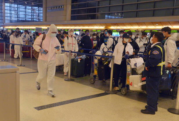 Hundreds of passengers form a line to check-in and board a China Southern Airlines midnight flight to China on Sunday, April 19, 2020 in Los Angeles. Passengers at the front of the line arrived at 5:30 a.m., with many others standing in line since 8 a.m. to ensure they would have a seat before the plane was full. Mayor Eric Garcetti said 95% of air travel has stopped in his city as Los Angeles sees the biggest drop of airplane travel in LAX history.  LAP2020041904 JIMxRUYMEN