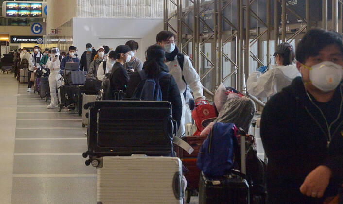 Hundreds of passengers form a line to check-in and board a China Southern Airlines midnight flight to China on Sunday, April 19, 2020 in Los Angeles. Passengers at the front of the line arrived at 5:30 a.m., with many others standing in line since 8 a.m. to ensure they would have a seat before the plane was full. Mayor Eric Garcetti said 95% of air travel has stopped in his city as Los Angeles sees the biggest drop of airplane travel in LAX history.  LAP2020041907 JIMxRUYMEN