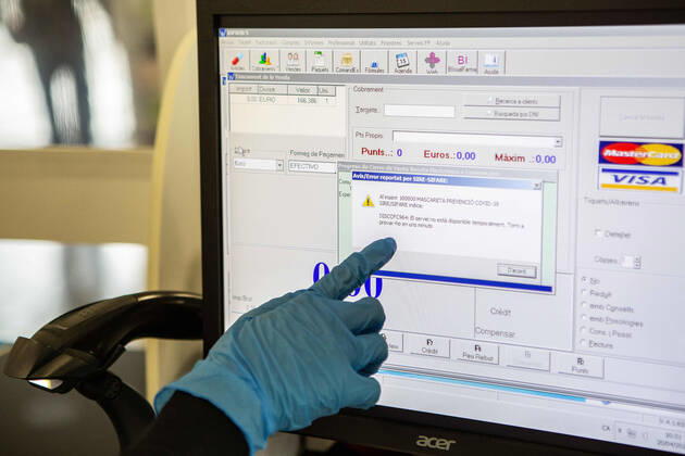 April 20, 2020, Girona, Spain: A pharmacist showing a system error on a computer screen during the Coronavirus (COVID-19) crisis..The Health Ministry has distributed facial masks to all pharmacies so that users can obtain them for free, they only deliver one mask per person on showing a medical card. Each user will receive one free facial mask per week. In the first hour, they started shipping, but the system collapsed due to high demand and currently it™s not possible to get face masks until the system is reset. Girona Spain - ZUMAs197 20200420_zaa_s197_016 Copyright: xMartixNavarrox