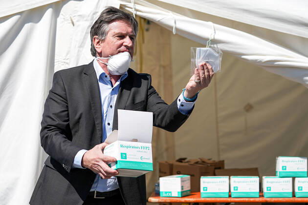 Baden-Württembergs Gesundheitsminister Manfred Lucha (Manne Lucha, Minister für Soziales und Integration, Bündnis 90 Die Grünen) begutachtet bei der Übergabe eine hochwertige Gesichtsmaske der Güteklasse FFP2, die zum medizinischen Gebrauch bestimmt ist, hohe Qualität, Verteilzentrum in der Feuerwache, Corona, Coronakrise, Symbolfoto, Symbolbild, Symbol, symbolische Übergabe, Einzelbild, 20.04.2020, Heidelberg (Deutschland), Pressetermin, Coronavirus, Heidelberg überreicht Masken an das Land Baden-Württemberg