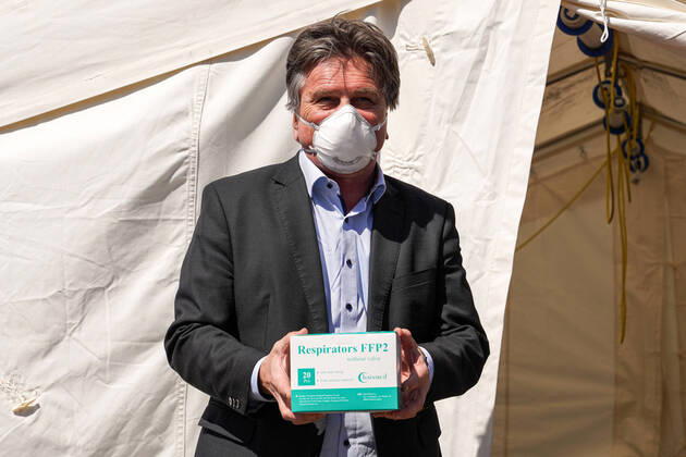 Baden-Württembergs Gesundheitsminister Manfred Lucha (Manne Lucha, Minister für Soziales und Integration, Bündnis 90 Die Grünen) hält bei der Übergabe eine Packung Gesichtsmasken der Qualität FFP2 in der Hand, mit Gesichtsmaske, Einzelbild, Verteilzentrum in der Feuerwache, Corona, Coronakrise, 20.04.2020, Heidelberg (Deutschland), Pressetermin, Coronavirus, Heidelberg überreicht Masken an das Land Baden-Württemberg