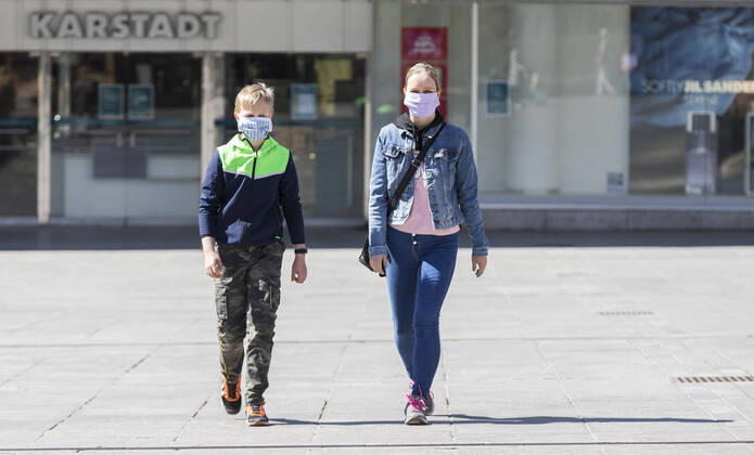 Deutschland, , , 20.04.2020, Presse, COVID-19 Deutschland faehrt langsam wieder hoch Bild: In Hessen haben die Geschaefte wieder geoeffnet, in Bayern nicht. Das wirkt sich vor allem auf die Osthessische Stadt Fulda aus, die nicht weit von der Bayerischen Landesgrenze entfernt liegt. Eine Frau und ein Kind laufen mit Mundschutz durch Fulda. Im Hintergrund ist die Karstadt Filliale, die allerdings noch geschlossen bleiben muss. Copyright: HMBxMedia OliverxMueller