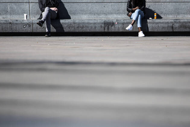 Zwei Personen sitzen auf einer Steinbank mit Abstand, aufgenommen in Berlin, 20.04.2020. Aufgrund der Verbreitung des Coronaviruses gibt es deutschlandweit Kontaktbeschraenkungen. Berlin Deutschland