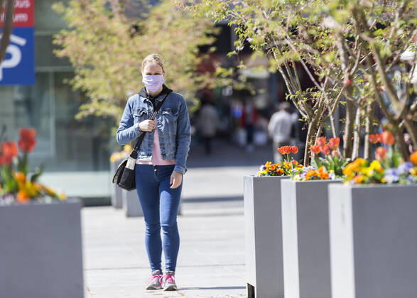 Deutschland, , , 20.04.2020, Presse, COVID-19 Deutschland faehrt langsam wieder hoch Bild: In Hessen haben die Geschaefte wieder geoeffnet, in Bayern nicht. Das wirkt sich vor allem auf die Osthessische Stadt Fulda aus, die nicht weit von der Bayerischen Landesgrenze entfernt liegt. Eine Frau läuft mit Mundschutz durch Fulda. Copyright: HMBxMedia OliverxMueller