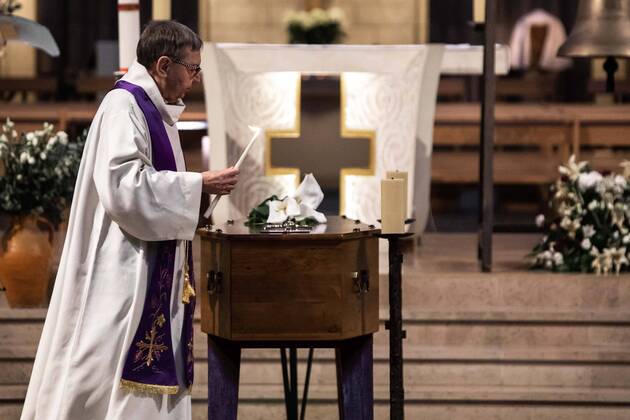 Paris, France, April 20, 2020 - Burial of a Coronavirus (Covid-19) victim at the Basilica Notre Dame du Perpetuel Secours, in the presence of only a few family members - The priest lights the candles around the coffin.  Copyright: xAlexisxSciardx