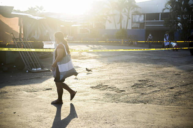 April 20, 2020, San Salvador, El Salvador: A woman wearing a face mask walks along police tape blocking the entrance to a plaza..A partial lockdown was placed in the cityÃ‚Â s downtown area. Soldiers and police officer have set dozens of control point to ensure people comply with the measures..El Salvador reports 218 cases and 7 deaths due to the novel Coronavirus. San Salvador El Salvador - ZUMAf143 20200420_zip_f143_002 Copyright: xCamiloxFreedmanx