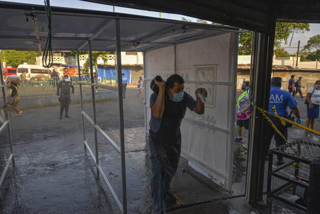 April 20, 2020, San Salvador, El Salvador: A man is sprayed while going thru a sanitization tunnel..A partial lockdown was placed in the cityÃ‚Â s downtown area. Soldiers and police officer have set dozens of control point to ensure people comply with the measures..El Salvador reports 218 cases and 7 deaths due to the novel Coronavirus. San Salvador El Salvador - ZUMAf143 20200420_zip_f143_005 Copyright: xCamiloxFreedmanx