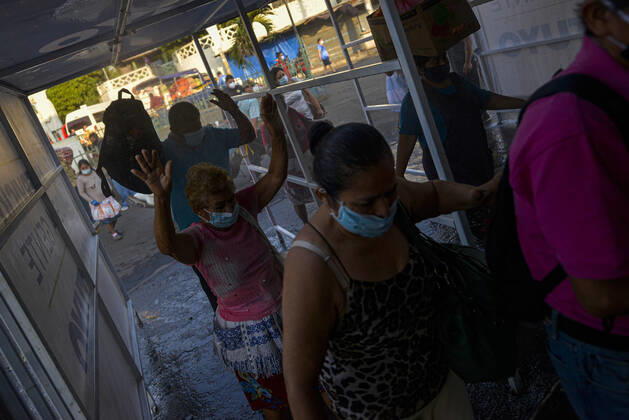 April 20, 2020, San Salvador, El Salvador: People are sprayed while going thru a sanitization tunnel..A partial lockdown was placed in the cityÃ‚Â s downtown area. Soldiers and police officer have set dozens of control point to ensure people comply with the measures..El Salvador reports 218 cases and 7 deaths due to the novel Coronavirus. San Salvador El Salvador - ZUMAf143 20200420_zip_f143_006 Copyright: xCamiloxFreedmanx