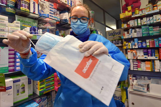 April 20, 2020, Vendrell, Spain: A pharmacist shows a free surgical mask provided by the Government of Catalonia to the citizens during the coronavirus pandemic..The pharmacies of Catalonia (Spain) today began to distribute surgical masks to prevent further contagion due to the Covid-19 health crisis that the Government of Catalonia sends to the population. Each citizen is assigned a free mask that is validated with their health cards and if they need a second one the citizen will have to pay for it. Vendrell Spain - ZUMAs197 20200420_zaa_s197_041 Copyright: xRamonxCostax