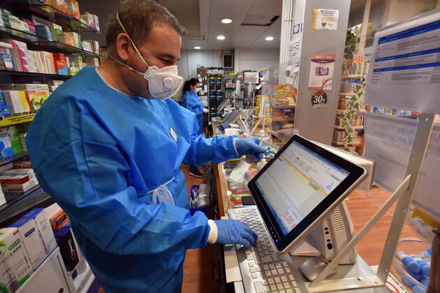 April 20, 2020, Vendrell, Spain: A pharmacist checks a citizens health card in order to receive a free mask provided by the Government of Catalonia in a pharmacy..The pharmacies of Catalonia (Spain) today began to distribute surgical masks to prevent further contagion due to the Covid-19 health crisis that the Government of Catalonia sends to the population. Each citizen is assigned a free mask that is validated with their health cards and if they need a second one the citizen will have to pay for it. Vendrell Spain - ZUMAs197 20200420_zaa_s197_045 Copyright: xRamonxCostax