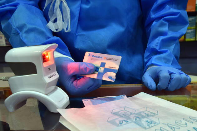April 20, 2020, Vendrell, Spain: A pharmacist checks a citizens health card in order to receive a free mask provided by the Government of Catalonia in a pharmacy..The pharmacies of Catalonia (Spain) today began to distribute surgical masks to prevent further contagion due to the Covid-19 health crisis that the Government of Catalonia sends to the population. Each citizen is assigned a free mask that is validated with their health cards and if they need a second one the citizen will have to pay for it. Vendrell Spain - ZUMAs197 20200420_zaa_s197_046 Copyright: xRamonxCostax