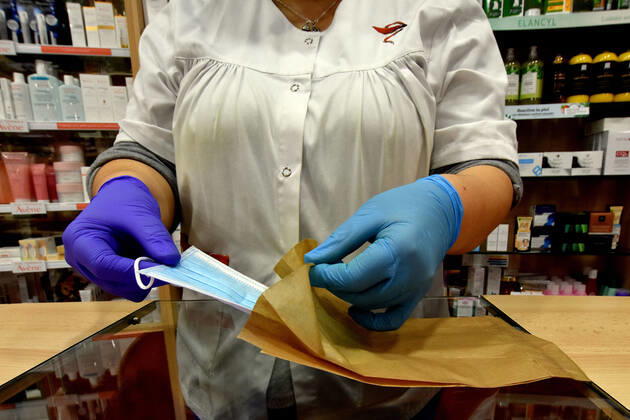April 20, 2020, Vendrell, Spain: A pharmacist places a free surgical mask in an envelop to deliver to a citizen..The pharmacies of Catalonia (Spain) today began to distribute surgical masks to prevent further contagion due to the Covid-19 health crisis that the Government of Catalonia sends to the population. Each citizen is assigned a free mask that is validated with their health cards and if they need a second one the citizen will have to pay for it. Vendrell Spain - ZUMAs197 20200420_zaa_s197_052 Copyright: xRamonxCostax