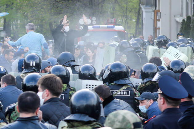 VLADIKAVKAZ, RUSSIA - APRIL 20, 2020: Riot police officer confront participants in a rally against the self-isolation order, in Svobody Square in front of the Palace of Justice. Non-working period was expanded in the Republic of North Ossetia till April 30, 2020 to prevent the spread of the novel coronavirus. Olga Smolskaya TASS  TS0D67B1