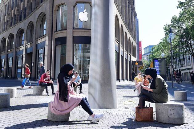 Coronavirus - Geschäftsöffnungen am 20.04.2020 in Köln Zwei Apple-Kundinnen sitzen vor dem verschlossenen Apple-Store. Ab dem 20.04.2020 dürfen erstmals seit der angeordneten Schließung in der Corona-Krise bestimmte Läden wieder öffnen. Doch es gibt viel zu beachten, die Regelungen sind nicht im ganzen Bundesgebiet einheitlich.