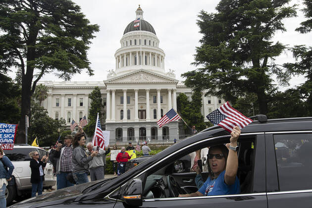 April 20, 2020, Sacramento, CA, USA: Demonstrators drive around the California Capitol in Sacramento on Monday, April 20, 2020, to protest the state s stay-at-home orders to slow the spread of the coronavirus. Sacramento USA - ZUMAj89_ 20200420_zaf_j89_013 Copyright: xPaulxKitagakixJr.x