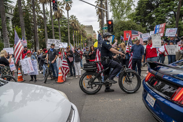 April 21, 2019, Sacramento, California, USA: Sacramento Police officers ride between demonstrators in cars and on the street that converged on the California Capitol in Sacramento on Monday, April 20, 2020, to protest the state s stay-at-home orders to slow the spread of the coronavirus. Sacramento USA - ZUMAby1_ 20190421_zap_by1_008 Copyright: xRenÃ exC.xByerx
