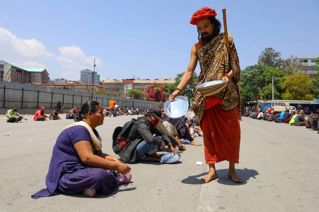 Nepal: Serving food to daily wager laborers A follower of Gorakhnath serves plate before food to the daily wager laborers, during the nationwide lockown imposed in the wake of corona virus (COVID-19) Pandemic in Kathmandu, Nepal on April 20, 2020. Kathmandu Bagmati Nepal Copyright: SubashxShrestha