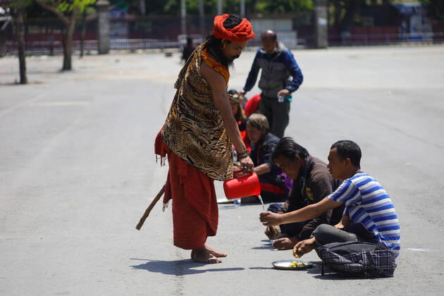 Nepal: Serving food to daily wager laborers A follower of Gorakhnath serves water to the daily wager laborers, during the nationwide lockown imposed in the wake of corona virus (COVID-19) Pandemic in Kathmandu, Nepal on April 20, 2020. Kathmandu Bagmati Nepal Copyright: SubashxShrestha