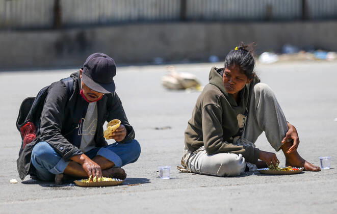 April 20, 2020, Kathmandu, Nepal: Homeless and needy people enjoy a free meal served at the roadside on the 28th day of a nationwide lockdown..Nepal government-imposed nationwide lockdown as a preventive measure against the spread of COVID-19 coronavirus. Kathmandu Nepal - ZUMAs197 20200420_zaa_s197_085 Copyright: xSunilxPradhanx