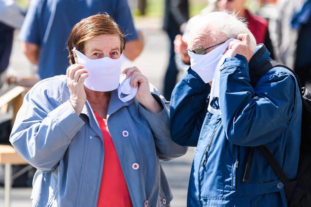 (200420) -- DRESDEN (GERMANY), April 20, 2020 (Xinhua) -- A man and a woman put on face masks received in front of the City Hall of Dresden, Saxony state, eastern Germany, on April 20, 2020. The rate of new infections with COVID-19 in Germany continued to fall as the number of confirmed cases only increased by 1,775 within one day to almost 142,000, the Robert Koch Institute (RKI) announced on Monday. (Photo by Kevin Voigt Xinhua) GERMANY-DRESDEN-COVID-19-MEASURES 