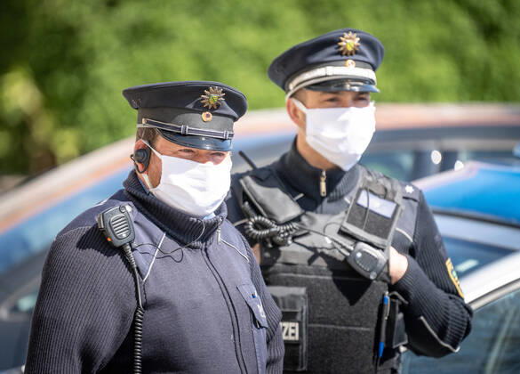 Polizisten mit Gesichtsmasken Polizisten mit Gesichtsmasken stehen vor dem Rathaus in Dresden. Tausende Dresdner haben am Montagmorgen vor dem Dresdner Rathaus für eine kostenlose Schutzmaske Schlange gestanden. Über mehrere hundert Meter standen die Bürger bis hin zur Goldenen Pforte, wo nach Angaben der Stadt rund 20 000 Mund-Nasenbedeckungen aus Stoff in den Farben schwarz oder weiß verteilt wurden. Pro Person wurde eine Maske ausgegeben - eine weitere durfte für Familienmitglieder mitgenommen werden. Insgesamt hat Oberbürgermeister Dirk Hilbert (FDP) rund 200 000 Masken geordert, die in den nächsten Tagen dezentral an Einwohner der Stadt verteilt werden sollen. Der Mund- und Nasenschutz stammt aus der Produktion von Dresdner Firmen. Seit Montag müssen Sachsen beim Einkaufen sowie in Bussen und Bahnen einen Mund- und Nasensch