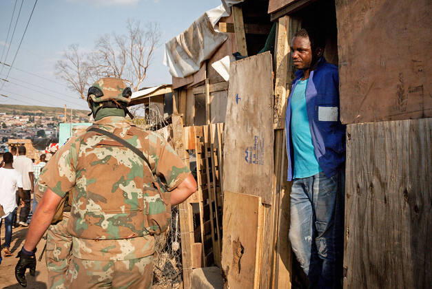 (200421) -- JOHANNESBURG, April 21, 2020 (Xinhua) -- A man watches soldiers of South African National Defense Force patrol in Johannesburg, South Africa, April 20, 2020. South Africa s COVID-19 cases have surged to 3,300, up by 142 from the previous count, Health Minister Zweli Mkhize said Monday. (Photo by Yeshiel Xinhua) SOUTH AFRICA-JOHANNESBURG-COVID-19 