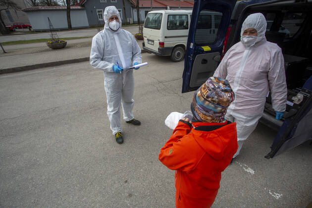 (200421) -- OGRE, April 21, 2020 (Xinhua) -- Staff members distribute free food to a child from low-income household in Ogre, Latvia, April 20, 2020. Latvia has extended the state of emergency till May 12. (Photo by Janis Xinhua) LATVIA-OGRE-COVID-19-FOOD DISTRIBUTION 