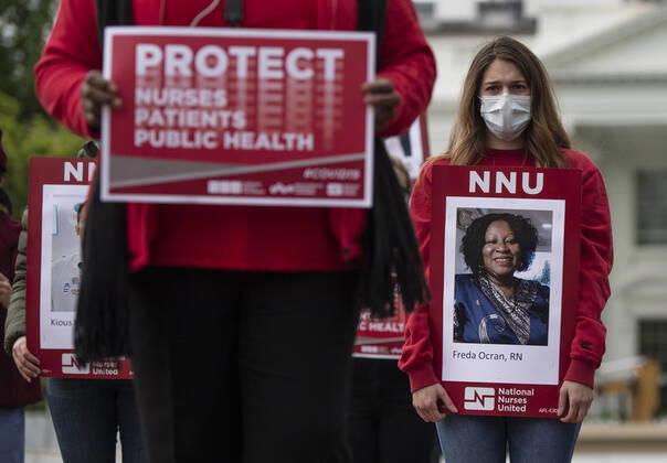 Registered Nurses hold photos of fellow nurses who have died from COVID-19 during a protest to calling attention on healthcare infections nationwide and demanding the Trump administration provide extra PPE for healthcare workers during the coronavirus pandemic, at the White House in Washington, D.C. on Tuesday, April 21, 2020.  WAP20200421302 KEVINxDIETSCH