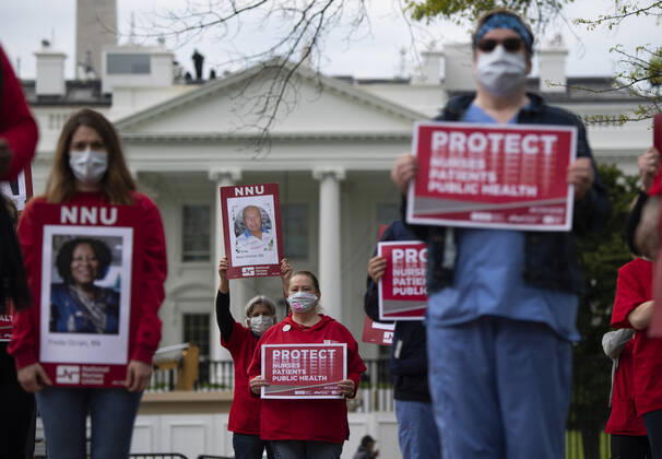 News Bilder des Tages Registered Nurses hold photos of fellow nurses who have died from COVID-19 during a protest to calling attention on healthcare infections nationwide and demanding the Trump administration provide extra PPE for healthcare workers during the coronavirus pandemic, at the White House in Washington, D.C. on Tuesday, April 21, 2020.  WAP20200421303 KEVINxDIETSCH