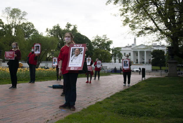 Registered Nurses hold photos of fellow nurses who have died from COVID-19 during a protest to calling attention on healthcare infections nationwide and demanding the Trump administration provide extra PPE for healthcare workers during the coronavirus pandemic, at the White House in Washington, D.C. on Tuesday, April 21, 2020.  WAP20200421305 KEVINxDIETSCH