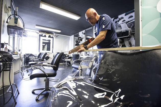 2020-04-21 14:55:30 ROTTERDAM - Kapper Nick plaats plastic in zijn kapsalon. Kappers hebben samen met de vakbonden een speciaal protocol opgesteld om kapsalons weer open te kunnen doen ondanks het nieuwe coronavirus. ANP PIETER STAM DE JONGE  Copyright: xPIETERxSTAMxDExJONGEx xANPx x409717555x