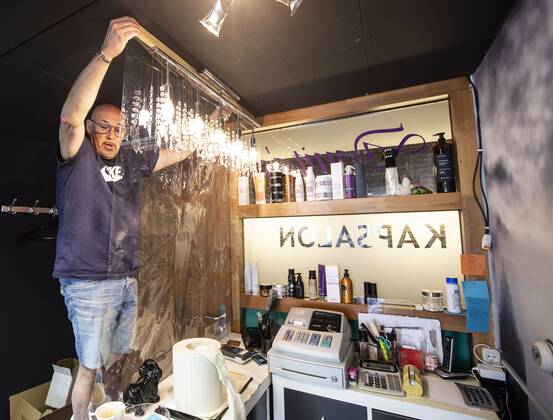 2020-04-21 15:02:40 ROTTERDAM - Kapper Nick plaats plastic in zijn kapsalon. Kappers hebben samen met de vakbonden een speciaal protocol opgesteld om kapsalons weer open te kunnen doen ondanks het nieuwe coronavirus. ANP PIETER STAM DE JONGE  Copyright: xPIETERxSTAMxDExJONGEx xANPx x409717572x