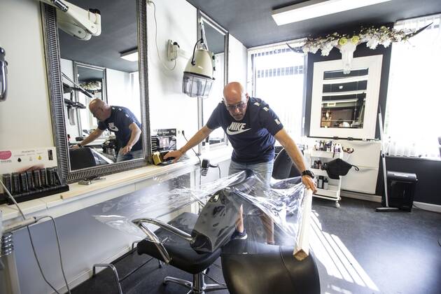 2020-04-21 15:14:32 ROTTERDAM - Kapper Nick plaats plastic in zijn kapsalon. Kappers hebben samen met de vakbonden een speciaal protocol opgesteld om kapsalons weer open te kunnen doen ondanks het nieuwe coronavirus. ANP PIETER STAM DE JONGE  Copyright: xPIETERxSTAMxDExJONGEx xANPx x409717580x