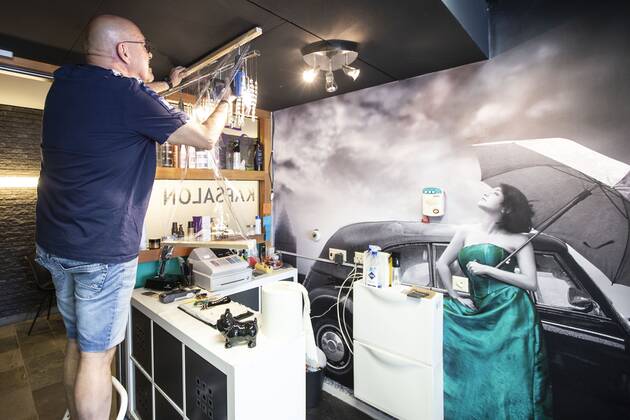 2020-04-21 15:57:46 ROTTERDAM - Kapper Nick plaats plastic in zijn kapsalon. Kappers hebben samen met de vakbonden een speciaal protocol opgesteld om kapsalons weer open te kunnen doen ondanks het nieuwe coronavirus. ANP PIETER STAM DE JONGE  Copyright: xPIETERxSTAMxDExJONGEx xANPx x409717585x
