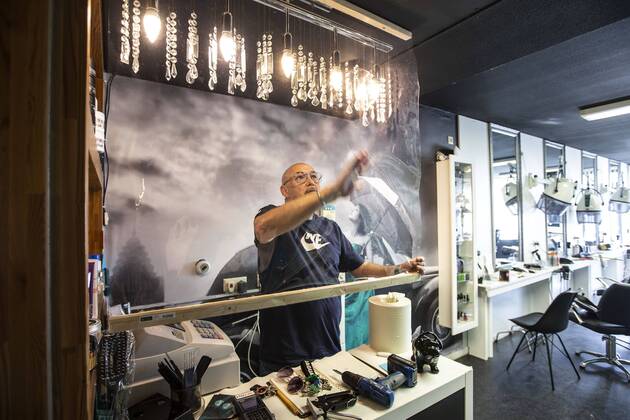 2020-04-21 16:00:46 ROTTERDAM - Kapper Nick plaats plastic in zijn kapsalon. Kappers hebben samen met de vakbonden een speciaal protocol opgesteld om kapsalons weer open te kunnen doen ondanks het nieuwe coronavirus. ANP PIETER STAM DE JONGE  Copyright: xPIETERxSTAMxDExJONGEx xANPx x409717591x