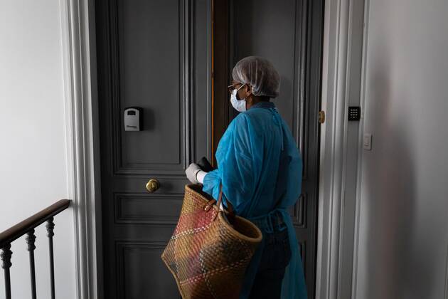 Paris, France, April 21, 2020 - Mrs. D., in her eighties, has just spent a dozen days in hospital after being infected with Coronavirus (Covid-19). Cured, she was able to return home, where Michele, a life assistant from the Neotine agency, goes several times a week to help her in her daily life - Michele comes back to the apartment after going to the supermarket  Copyright: xAlexisxSciardx
