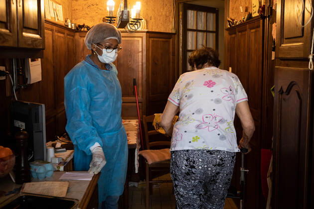 Paris, France, April 21, 2020 - Mrs. D., in her eighties, has just spent a dozen days in hospital after being infected with Coronavirus (Covid-19). Cured, she was able to return home, where Michele, a life assistant from the Neotine agency, goes several times a week to help her in her daily life - Michele is making lunch  Copyright: xAlexisxSciardx