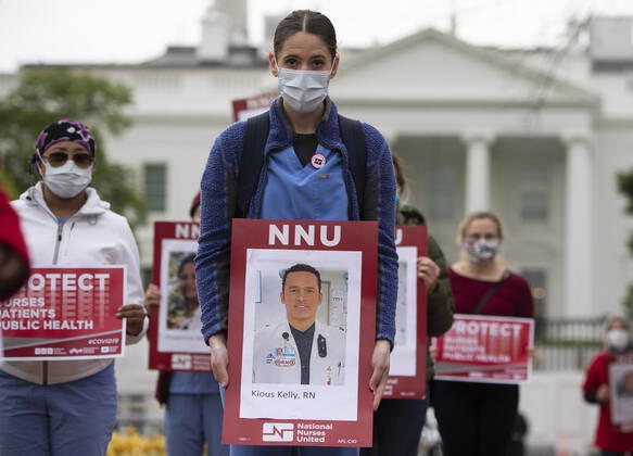 Nurses hold photos of fellow healthcare workers who have died from COVID-19 during a protest calling attention on healthcare infections nationwide and demanding the Trump administration to provide extra PPE for healthcare workers during the coronavirus pandemic, at the White House in Washington, D.C. on Tuesday, April 21, 2020.  WAP20200421318 KEVINxDIETSCH