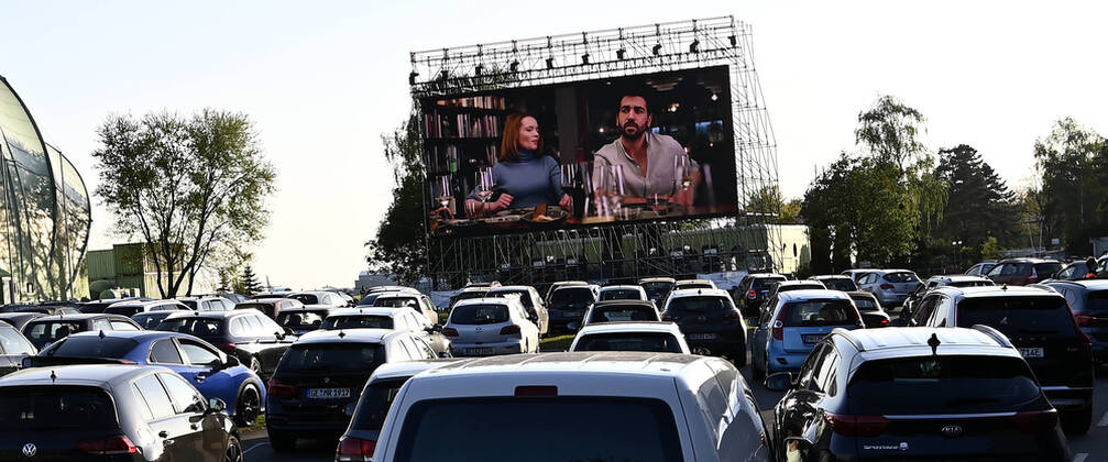CORONA-PANDEMIE,CORONAVIRUS,COVID-19.Das Autokino ist wieder Kult.Motor Movie ist ein temporäres Autokino in Mülheim-Ruhr,Stadt im Ruhrgebiet,im Bundesland Nordrhein-Westfalen ( NRW ).Die Leinwand steht auf dem Gelände des Flughafens Essen Mülheim und ist Dank einer riesigen LED-Leinwand von 9x16 Metern,die auch bei Tageslicht ein gestochen scharfes Kinoerlebnis bietet.Das fast in Vergessenheit geratene Autokino,erlebt wieder einen Hype-Autokino ist wieder Kult,das Programm bietet ein vielfältiges sowie familienfreundliches Programm,fotografiert am 21.04.2020. Â