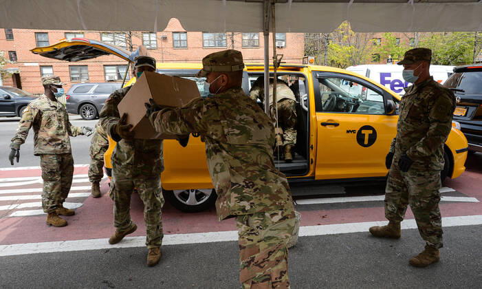 April 21, 2020, New York Manhattan, USA: National guard placing boxes of food inside the taxi. The Taxi and Limousine Commission, or TLC, which is responsible for licensing and regulating taxis and other for-hire vehicles in New York City, is encouraging its drivers to sign up for the meal delivery program .04 21 20. New York Manhattan. New York Manhattan USA - ZUMAs252 20200421_znp_s252_015 Copyright: xMarcusxSantosx