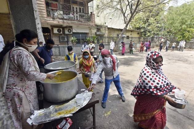 NEW DELHI, INDIA - APRIL 21: People queue to collect food distributed by BJP councilor Shikha Rai during lockdown to curb spread of coronavirus, at Shahpur Jat, on April 21, 2020 in New Delhi, India. (Photo by Sanjeev Verma Hindustan Times) Government And NGOs Provide Food To Homeless And Poor Amid Lockdown To Prevent Covid-19 Pandemic