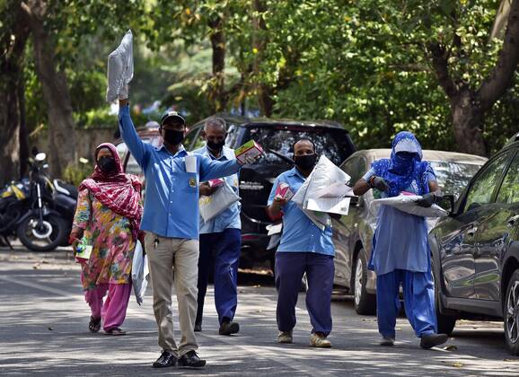 NEW DELHI, INDIA - APRIL 21: Cleaning staff leave after collecting PPE kits distributed by Defence Colony welfare groups in association with SDMC during lockdown, at Defence Colony, on April 21, 2020 in New Delhi, India. (Photo by Sanjeev Verma Hindustan Times) PPE Kits Distributed To SDMC Sanitation Staff