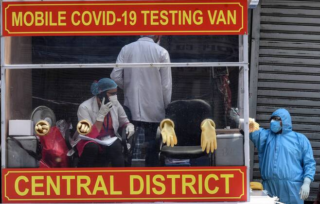 NEW DELHI, INDIA - APRIL 21: Health workers in a mobile testing van before taking swab samples from residents of the Hauz Qazi area for COVID-19 antibody rapid testing as a precautionary measure during lockdown on April 21, 2020 in New Delhi, India. (Photo by Biplov Bhuyan Hindustan Times) Antibody Rapid Testing In Delhi In View Of Covid-19 Pandemic