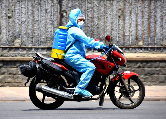 NEW DELHI, INDIA - APRIL 21: A man wearing PPE seen on a motorbike at JLN marg during lockdown on April 21, 2020 in New Delhi, India. (Photo by Sonu Mehta Hindustan Times) Sanitization Drive To Curb The Spread Of Coronavirus COVID-19