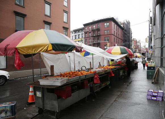 A customer is served at an outdoor fruit market in the Chinatown section of Manhattan in New York City on Tuesday, April 21, 2020. An estimated 2.5 million people have been infected with the new coronavirus globally and It has killed more than 171,000 people worldwide. About 25% of those deaths have been recorded in the United States.  NYP20200421109 JOHNxANGELILLO