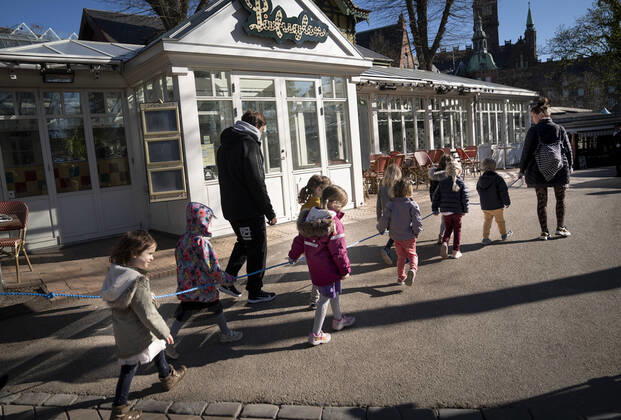 Covid-19: Koebenhavns Kommunes institutioner med pladsmangel, kan i disse dage, hvor flere og flere boern vender tilbage til deres dagtilbud, benytte arealer i Tivoli, bla. Rasmus Klumps legepladsen, i Koebenhavn onsdag den 22. april 2020. Vuggestueboern fra Vartov og boernehaveboern fra Boernebyen Vandvaerket leger i Tivoli. Boernene maa p.g.a corona ikke gaa haand i haand, saa boernehaven har opfundet afstandssnoren . , Copenhagen Denmark