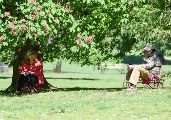. 22 04 2020. London, United Kingdom. Coronavirus crisis. A man and a woman are photographed enjoying the sunshine seated on foldable chairs at Battersea Park this afternoon as the coronavirus lockdown continues.  xGustavoxValientex xi-Imagesx IIM-21051-0007