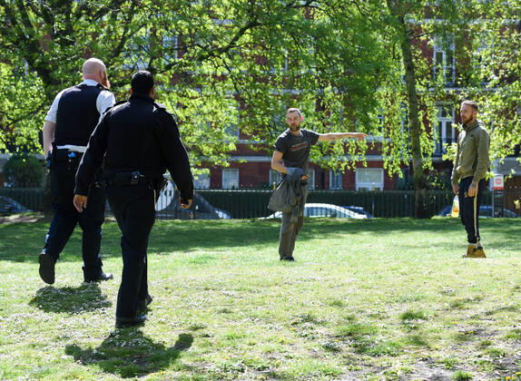 . 22 04 2020. London, United Kingdom. Coronavirus crisis. Two police officers are photographed talking to two builders, who were enjoying the sunshine during a break at Battersea Park this afternoon as the coronavirus lockdown continues.  xGustavoxValientex xi-Imagesx IIM-21051-0016
