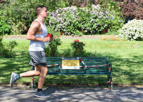 . 22 04 2020. London, United Kingdom. Coronavirus crisis. A runner passes in front of a closed bench at Kennington Park this afternoon, as the coronavirus lockdown continues.  xGustavoxValientex xi-Imagesx IIM-21051-0028